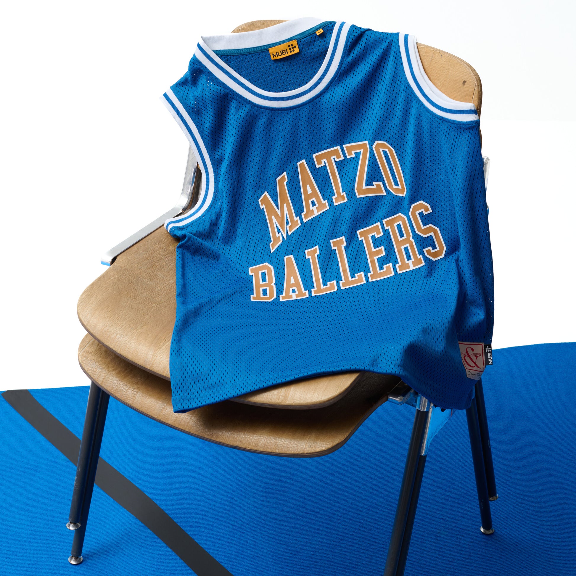 Blue basketball jersey with 'Matzo Ballers' text on a chair against a blue background