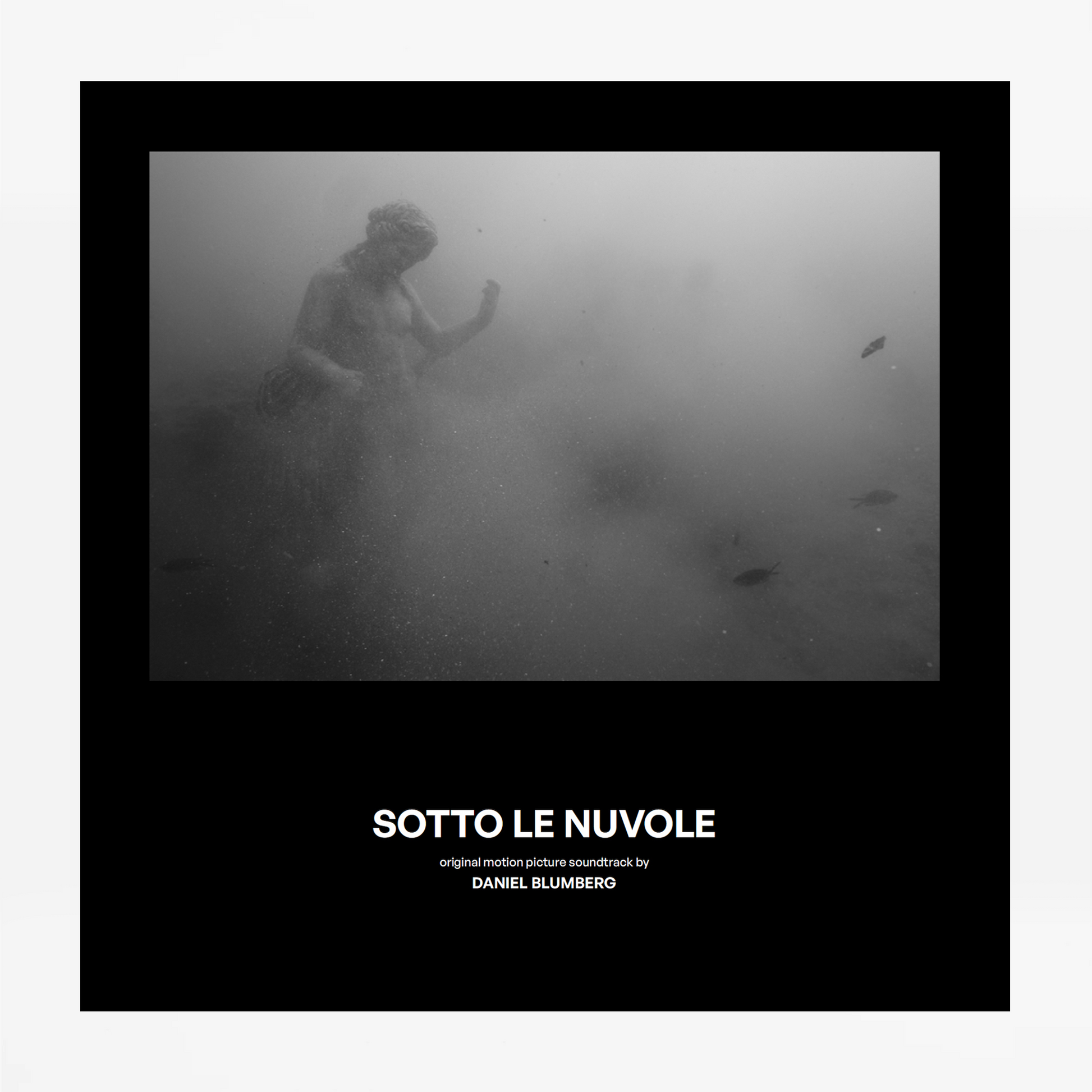Black and white underwater scene with a person holding a light source, text 'SOTTO LE NUVOLE (POMPEI: BELOW THE CLOUDS) ORIGINAL MOTION PICTURE SOUNDTRACK' by Daniel Blumberg at the bottom.