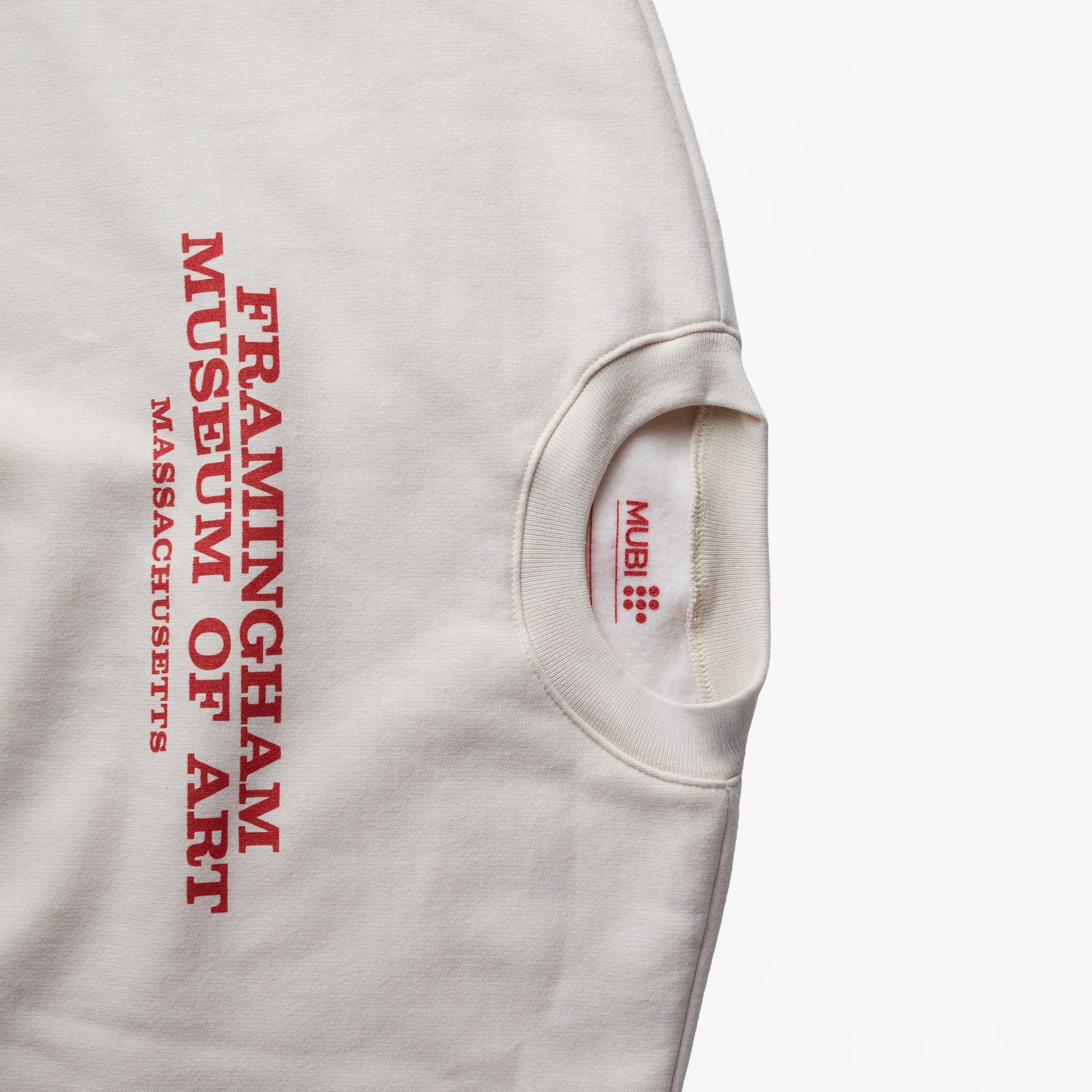 Close-up of THE MASTERMIND cream sweatshirt and the "FRAMINGHAM MUSEUM OF ART MASSACHUSETTS" on the front
